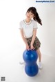 A young woman sitting on top of a blue ball.